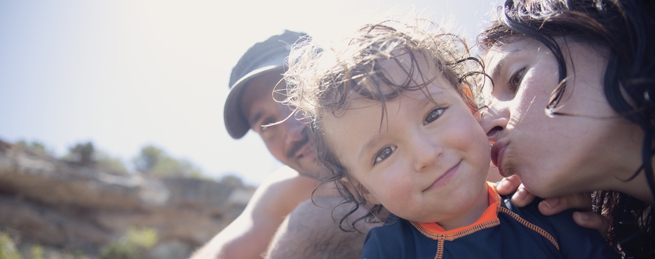 Kind met ouders op het strand in de zon