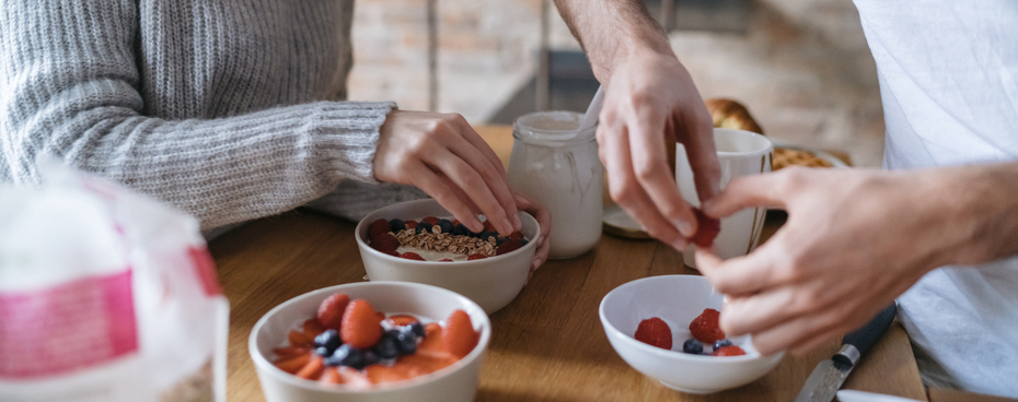man en vrouw maken yoghurt met fruit als ontbijt