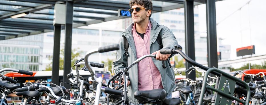 Persoon bij gestalde fietsen op een stationslocatie