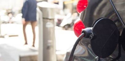 Een straat waar een elektrische auto aan de laadpaal staat op te laden