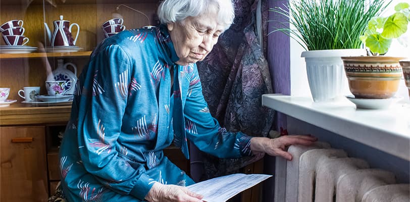 A senior woman reading her bills at home