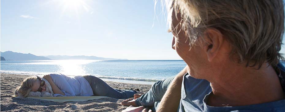 Man en vrouw liggen op het strand
