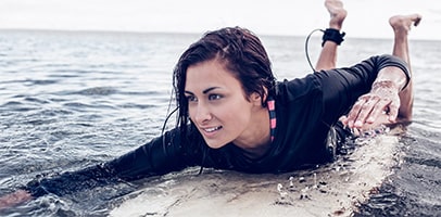 Jonge vrouw op surfplank in zee