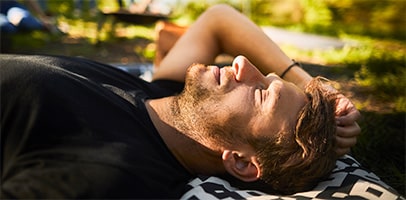 Relaxte jonge man ligt in gras