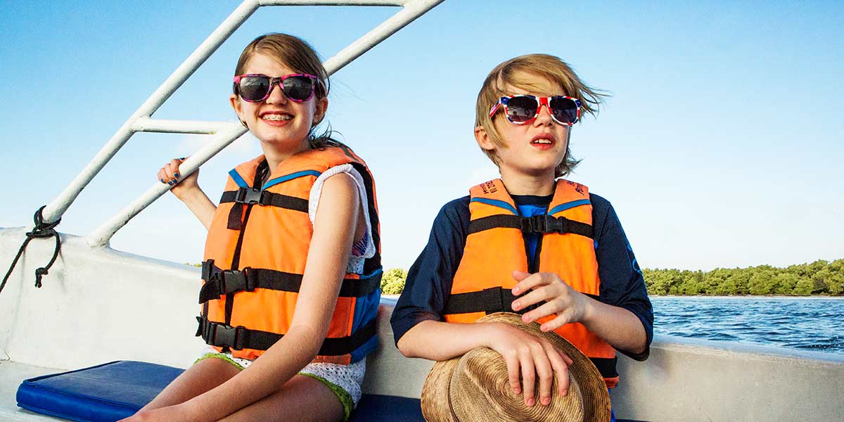 Veilig varen met kinderen: 2 kinderen op een boot met zwemvest aan