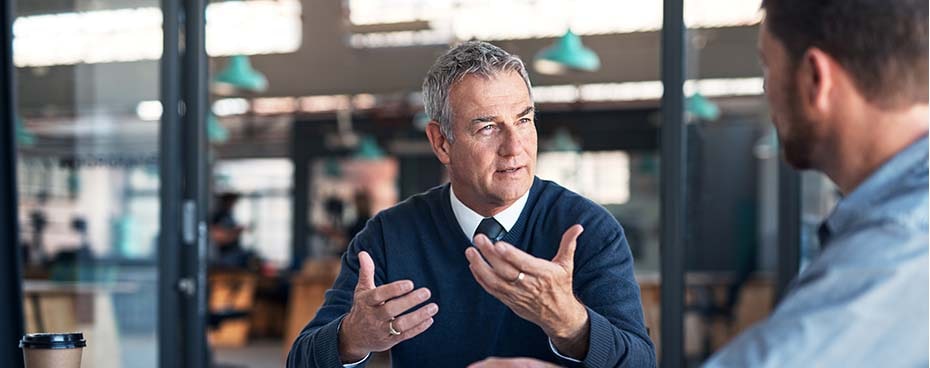 Man met collega in gesprek op kantoor
