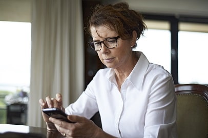 Vrouw zit met smartphone in haar hand