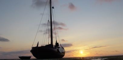 Een afbeelding van een zeilboot silhouet tegen een zonsondergang 