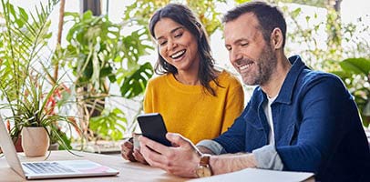 Lachende man en vrouw kijken naar zijn smartphone