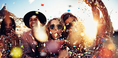Feestende jongeren blazen confetti 